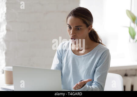 Schockiert und Frau am Laptop Bildschirm schaut betonte Stockfoto