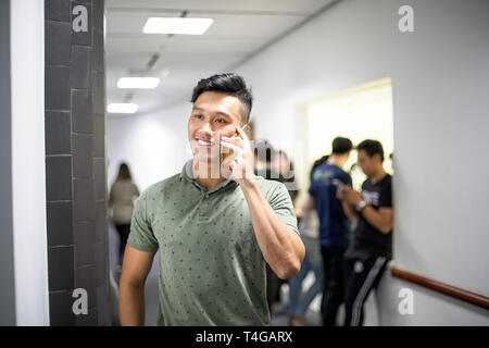 Asiatische stattliche Männer, die gerne am Telefon | Kerl Lächeln, während Sie ihr Smartphone Stockfoto