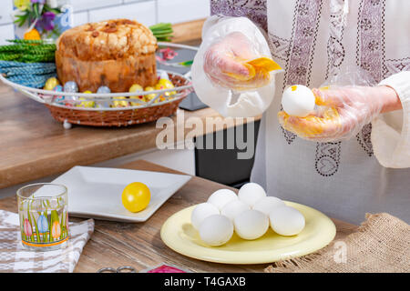 Die hand drückt die Farbe auf dem Ei. malen Eier zu Ostern. Prozess des Malens die Eier Stockfoto