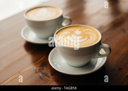 Zwei Tassen frischen Cappuccino auf dem Holztisch. Stockfoto