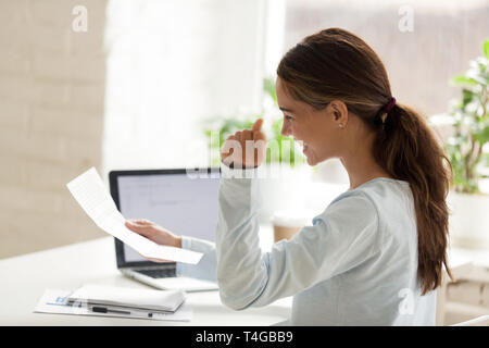 Profil von Happy woman holding Papier in der Hand auf dem Desktop Stockfoto