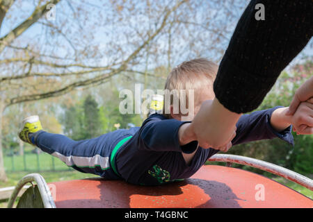 Mangels, Kinderbetreuung, Medizin und Personen Konzept: glückliche Mutter und Sohn mit Down-syndrom spielen zusammen in einem Park im Frühling. Stockfoto