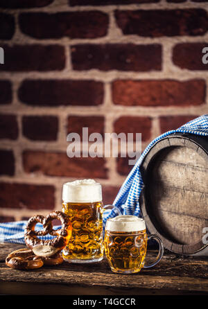 Oktoberfest große und kleine Bier mit brezel Holzfass und blau Tischdecke Stockfoto