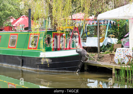 Kanal Boot neben Janes verzauberte Kaffee Garten auf der Oxford Canal an einem Frühlingsmorgen. Kirtlington, Oxfordshire, England Stockfoto