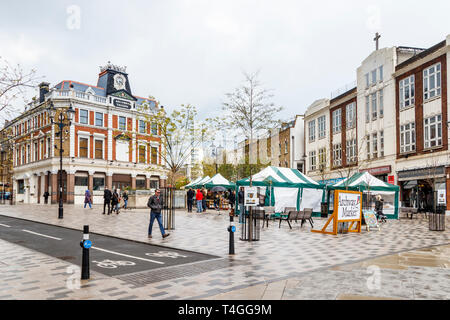 Der Markt am Samstag in Navigator Square, Torbogen, London, UK, als Regen gibt weg Sonnenschein an einem blustery Frühling zu Stockfoto