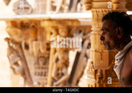 Heiliger Mann mit geschnitzten Steinfiguren in Chandraprabhu Jain Tempel Jaisalmer, Rajasthan, Indien Stockfoto