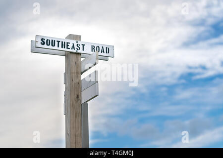 Alte hölzerne Wegweiser mit einem einfachen schwarzen und weißen Straße Zeichen den Weg in den Südosten Straße, Block Island, Rhode Island Stockfoto