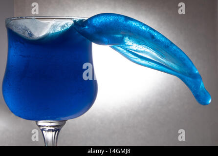 Blaues Wasser planschen in einem Glas Stockfoto