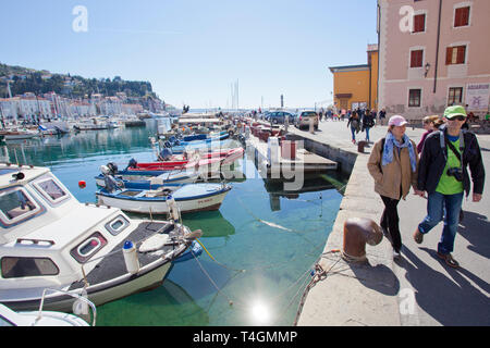 Menschen zu Fuß neben Boote in Piran günstig Stockfoto