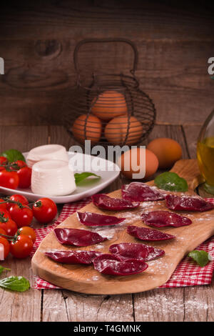 Rotes Herz Ravioli mit Tomate, Mozzarella und Basilikum. Stockfoto