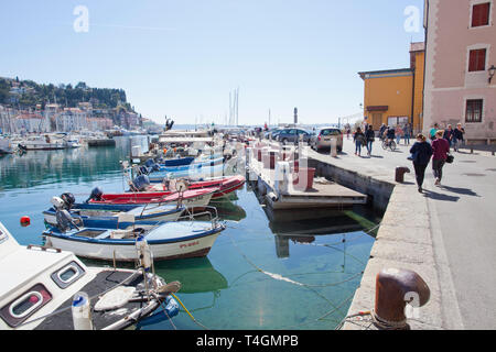 Menschen zu Fuß neben Boote in Piran günstig Stockfoto