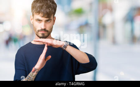 Jungen gutaussehenden Mann über isolierte Hintergrund tun time out Geste mit den Händen, frustriert und ernstes Gesicht Stockfoto
