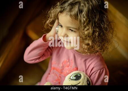 Mädchen, 3 Jahre, Porträt, sitzen auf der Treppe mit Handy, rief, Deutschland Stockfoto