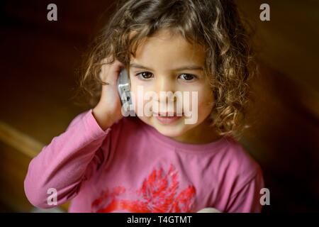 Mädchen, 3 Jahre, Porträt, sitzen auf der Treppe mit Handy, rief, Deutschland Stockfoto