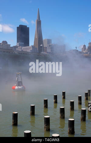 Das Exploratorium hergestellt Nebel wabert über die Bucht Gewässer mit iconic Skyline der Stadt im Hintergrund. Stockfoto