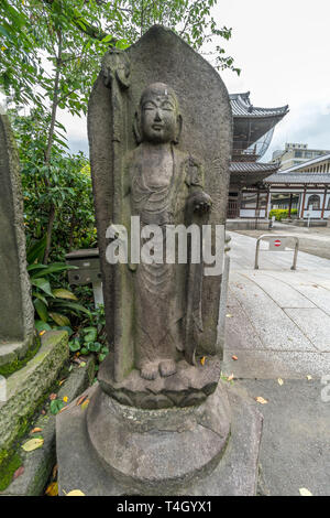 Weibliche Skulptur mit unlesbaren Inschriften an Sengaku-ji Soto Zen-buddhistischen Tempel. In Takanawa Bezirk Minato Bezirk, Tokyo, Japan. Stockfoto