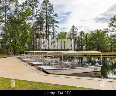 Okefenokee Swamp, Bucharest, GA, USA -3/29/19: Der Kanal am östlichen Eingang zum Sumpf, mit schnellbooten am Dock, und zwei Frauen im Hintergrund. Stockfoto