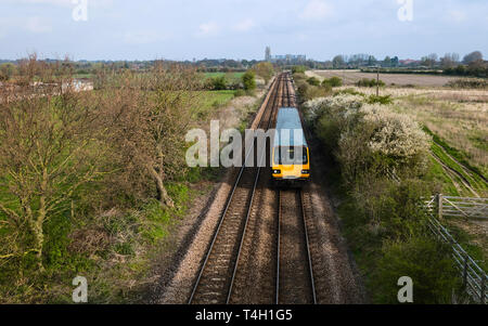 Eine Eisenbahn Zug Schnitte durch ländliche Landschaft an einem strahlenden Herbsttag mit alten Münster am Horizont in der Nähe von Beverley, Yorkshire, Stockfoto