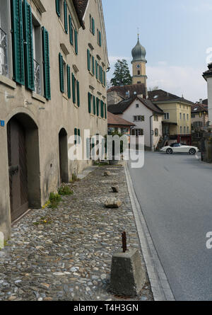 Maienfeld GR/Schweiz - April 13, 2019: historische Schweizer Dorf Maienfeld mit dem Stadtzentrum und Kirchturm und einen Oldtimer Auto überqueren Stockfoto