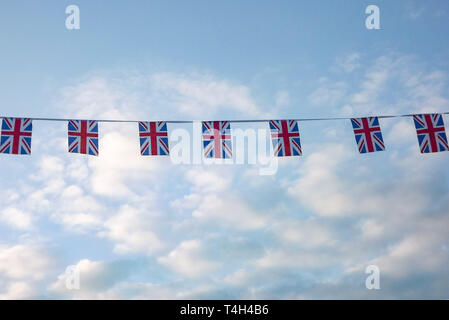 Union Flag bunting vor einem blauen bewölkten Himmel eingestellt Stockfoto