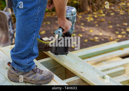 Heimwerker installation Holzböden in Terrasse, Arbeiten mit Hilfe von Bolzenschußgeräten zu nageln Stockfoto