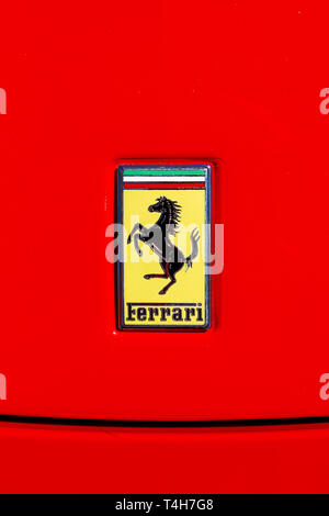 Nahaufnahme eines Ferrari Logo der "springende Pferd auf gelbem Schild, auf rotem Hintergrund. Stockfoto