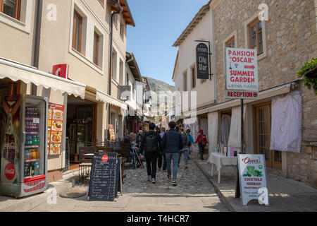 Mostar, Bosnien und Herzegowina - April 2019: Mostar Altstadt. Touristen zu Fuß in die Market Street. Stockfoto