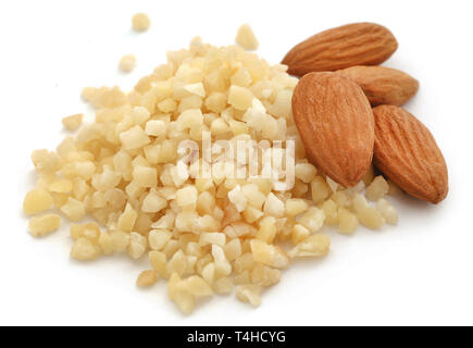Kleine Stücke gehackten Mandeln mit ganzen, auf weißem Hintergrund Stockfoto