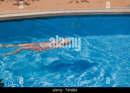 Eine Frau beim Rückschlag im Schwimmbad Stockfoto