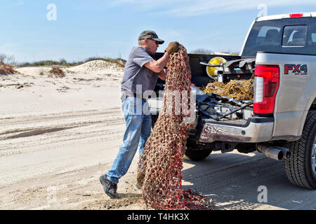 Freiwillige laden F250 Ford Truck, Reinigung, Entfernen von hanfseil Cargo Net, Angeln & Sonstiges andere Kunststoff Papierkorb gewaschen an Land. Stockfoto