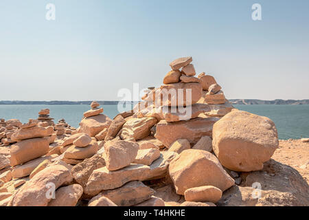 Damm der Steine platziert konisch eine über der anderen, als eine Opfergabe, die von Touristen in Abu Simbel, Assuan, Ägypten Stockfoto