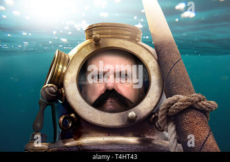 Porträt des Menschen in alten Taucheranzug und Helm unter Wasser. Lustige Taucher im Retro-look. Stockfoto