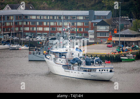 Kinsale, Cork, Irland. 17. April 2019. Super Yacht Capella C kommt an der Pier, wo das Kriegsschiff LÉ Orla bereits auf einem nebligen Morgen in Kinsale, Co Cork angedockt ist. Die 59 Meter Yacht wurde 1968 erbaut und kann 20 Gäste mit einer Crew von 17 tragen. Stockfoto