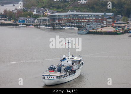 Kinsale, Cork, Irland. 17. April 2019. Super Yacht Capella C kommt an der Pier, wo das Kriegsschiff LÉ Orla bereits auf einem nebligen Morgen in Kinsale, Co Cork angedockt ist. Die 59 Meter Yacht wurde 1968 erbaut und kann 20 Gäste mit einer Crew von 17 tragen. Stockfoto