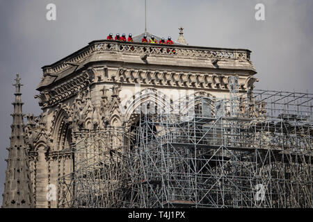 Paris, Frankreich. 17. Apr 2019. Feuerwehrmänner stehen auf dem Dach eines Turms der Pariser Kathedrale Notre-Dame. Das Feuer am Montag (15.04.2019) hatte die Kathedrale - ein wichtiges Wahrzeichen der französischen Hauptstadt und ein touristischer Magnet für Millionen von Menschen jedes Jahr besucht zerstört. Zur gleichen Zeit, das Feuer löste eine Welle der Hilfsbereitschaft. Foto: Marcel Kusch/dpa Quelle: dpa Picture alliance/Alamy leben Nachrichten Stockfoto