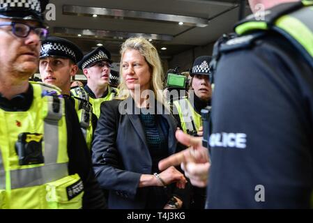 London, Großbritannien. 17 Apr, 2019. Ein Klimawandel Demonstrantin, die sich auf dem Dach eines DLR-Zug am Canary Wharf DLR Station geklebt wird von der Polizei geführt. Credit: Claire Dohert/Alamy leben Nachrichten Stockfoto