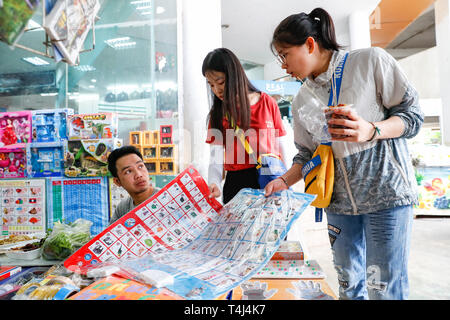 Vientiane, Laos. 24 Mär, 2019. Yao Changhua (R) und Lin Jieyu (C), zwei chinesische freiwillige Lehrkräfte bei Ban Nongping Grundschule, kaufen eine illustrierte Chinese-Lao Vokabular Blatt in Vientiane, Laos, 24. März 2019. Verbot Nongping Grundschule wurde im Jahr 2013 mit Hilfe von China gegründet. Credit: Wang Jingqiang/Xinhua/Alamy leben Nachrichten Stockfoto