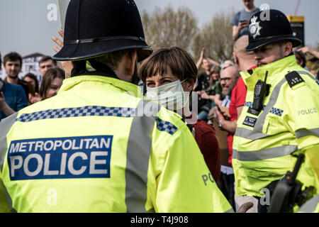 Eine weibliche Demonstrant zu einem Polizeioffizier Momente auf der Suche vor, während das Aussterben Rebellion Streik in London verhaftet wurde. Aussterben Rebellion Demonstranten haben fünf zentrale Wahrzeichen Londons gegen die Regierung Untätigkeit gegen den Klimawandel zu protestieren blockiert. Stockfoto