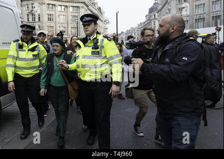London, Greater London, UK. 17 Apr, 2019. Polizisten gesehen, ein Aktivist in Oxford Circus während das Aussterben Rebellion Streik in London führen. Umweltschuetzer aus Aussterben Aufstandsbewegung halten sie für den dritten Tag in Folge Oxford Circus in London. Aktivisten eine rosa Boot mitten in Oxford Circus Kreuzung blockieren die Straßen und verursachen Störungen abgestellt war, Polizei verhaftete Demonstranten, die zu Marble Arch zu verweigern. Aussterben Rebellion fordert von der Regierung direkte Aktionen auf das Klima, die CO2-Emissionen auf Null zu reduzieren, indem Sie Stockfoto