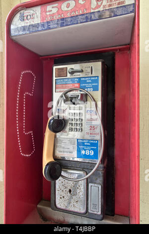 Klassisches Münztelefon mit Empfänger, Drucktaste und Münzauswurfschlitz. Stockfoto