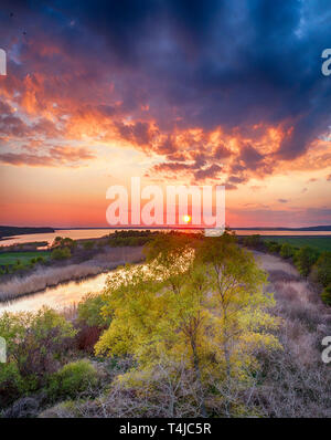 Schöne Landschaft mit feurigen Sonnenuntergang über dem See und Fluss in der Nähe von Burgas, Bulgarien. Luftaufnahme Stockfoto