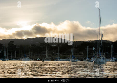 Monterey, Kalifornien/USA -06-11-2014: Editorial, Sonnenuntergang Monterey CA übersicht Segelboote im Hafen mit dem marine Schicht bilden im Hintergrund. Stockfoto