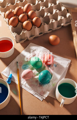 Eier, bunte Farben, Pinsel, Stifte auf einer hölzernen Hintergrund, färben Eier, die Vorbereitung auf Ostern, Frühling saison Urlaub Stockfoto