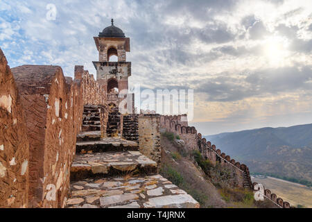 Alte lange Mauer mit Türmen um Amber Fort bei Sonnenuntergang. Jaipur. Rajasthan. Indien Stockfoto