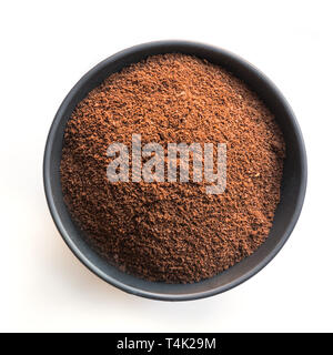 Gemahlener Kaffee Bohnen in schwarz Schüssel auf Weiß. Close Up. Blick von oben. Stockfoto
