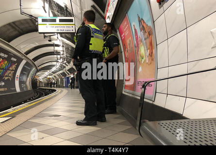 Britische Verkehrspolizisten patrouillieren auf der Central Line-Plattform der U-Bahn-Station Bank, als zwei Demonstranten des Extinction Rebellion an Bord einer Docklands Light Railway (DLR) am Bahnhof Canary Wharf im Osten Londons kletterten und sagten, sie würden sich selbst auf das Dach kleben, Im Rahmen der anhaltenden Klimaproteste in der Hauptstadt. Stockfoto