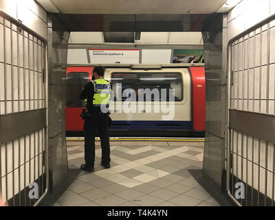 British Transport Polizisten auf Streife auf der Central Line Plattform der U-Bahnhof Bank als zwei Aussterben Rebellion Demonstranten an Bord die Beförderung eines Docklands Light Railway (DLR) an der Station Canary Wharf im Osten Londons erklommen und sagen Sie selbst Klebstoff auf dem Dach, im Rahmen der laufenden Klimawandel Proteste in der Hauptstadt. Stockfoto