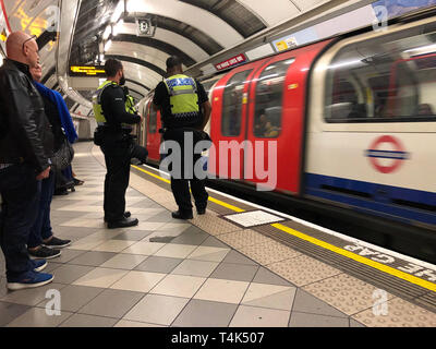 Britische Verkehrspolizisten patrouillieren auf der Central Line-Plattform der U-Bahn-Station Bank, als zwei Demonstranten des Extinction Rebellion an Bord einer Docklands Light Railway (DLR) am Bahnhof Canary Wharf im Osten Londons kletterten und sagten, sie würden sich selbst auf das Dach kleben, Im Rahmen der anhaltenden Klimaproteste in der Hauptstadt. Stockfoto