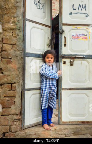 Amer Dorf, Indien - Januar 30, 2019: Porträt der jungen indischen Mädchen in der Nähe der Türen in Bernstein Dorf. Rajasthan Stockfoto