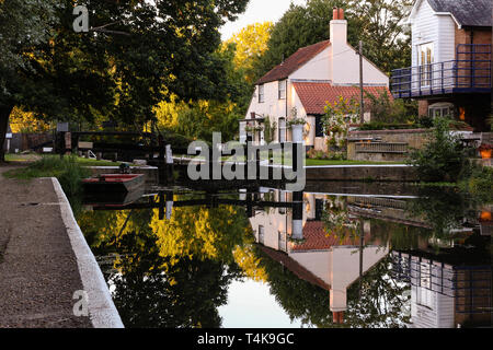 Scharfe und klare Reflexion einer lock keepers Cottage entlang des Flusses Wey Navigation Canal in der Nähe von Weybridge Stockfoto